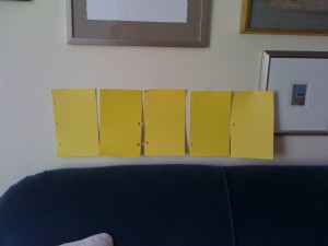 Yellow paint swatches above blue sofa Yellow paint swatches above blue sofa