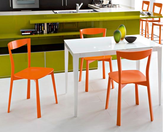 Orange chairs, white table, green shelves
