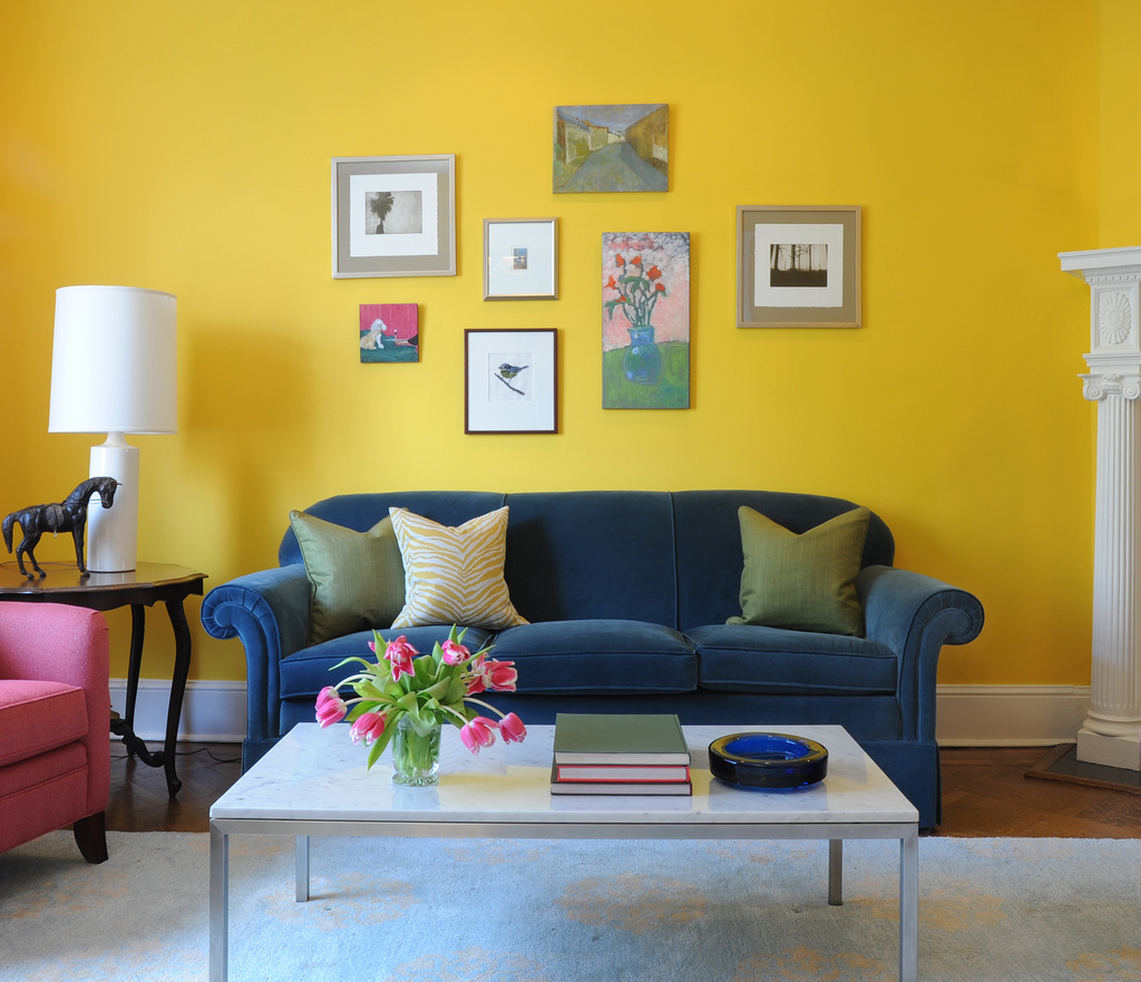 Yellow living room with blue velvet sofa