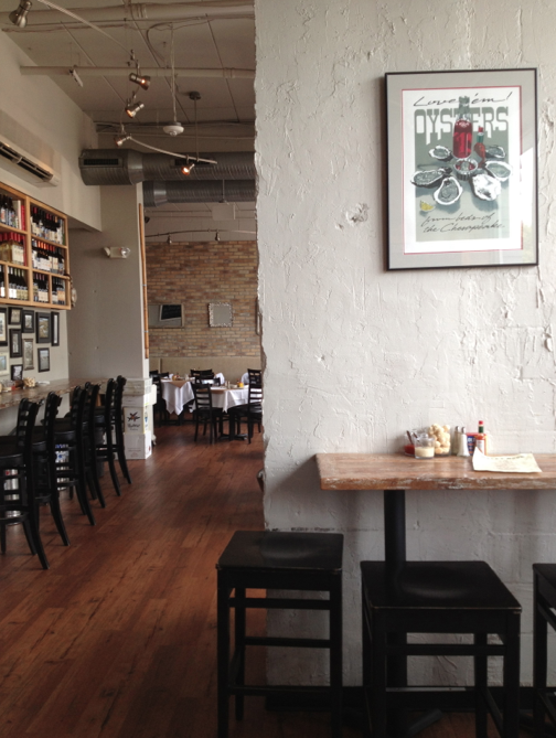 Gray walls with natural wood floor at an oyster restaurant