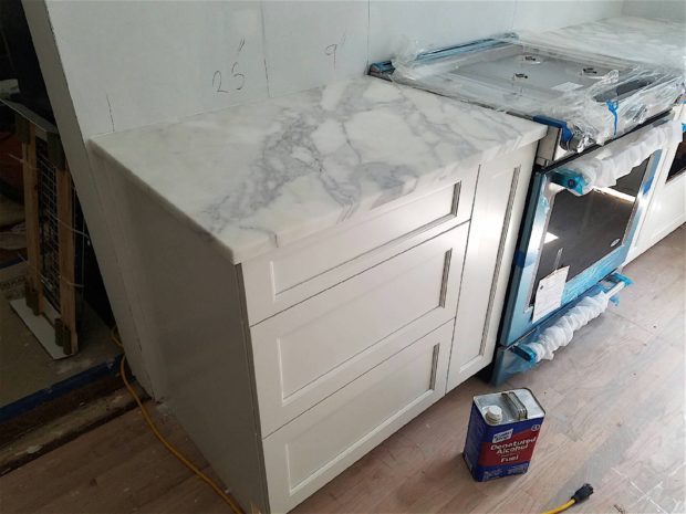 Marble kitchen countertop being installed in renovation