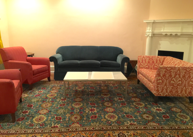 Pink walls with blue sofa and teal oriental rug