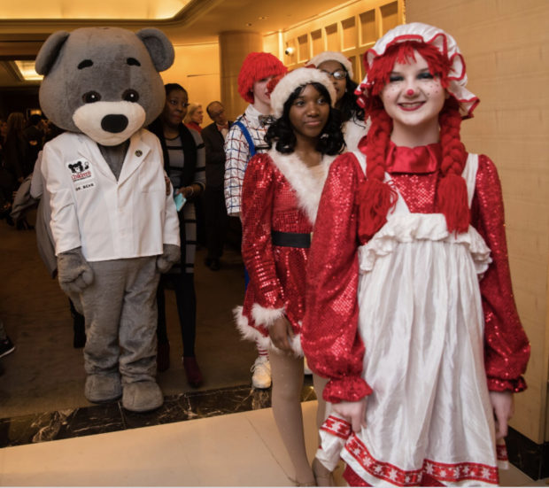 Stuffed bear with children in Christmas costumes