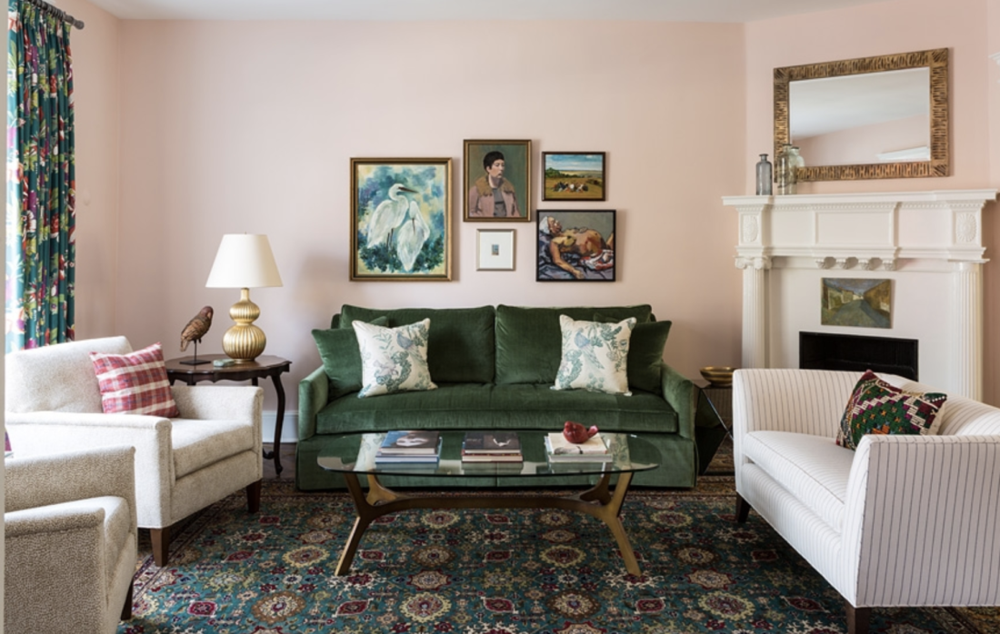 Pink living room with dark green sofa and Oriental rug