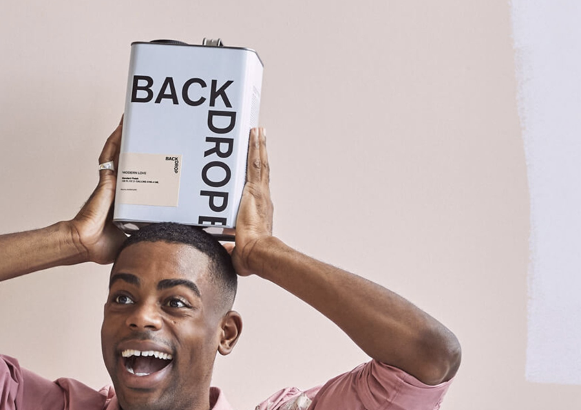 Smiling man holding a can of paint