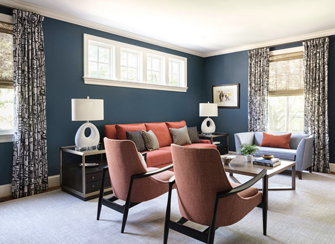 Navy blue living room with orange sofa and chairs