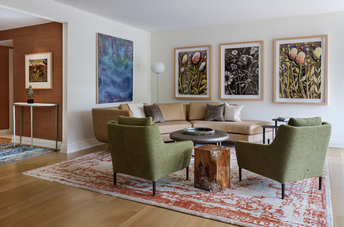 Modern living room with green chairs and large artwork