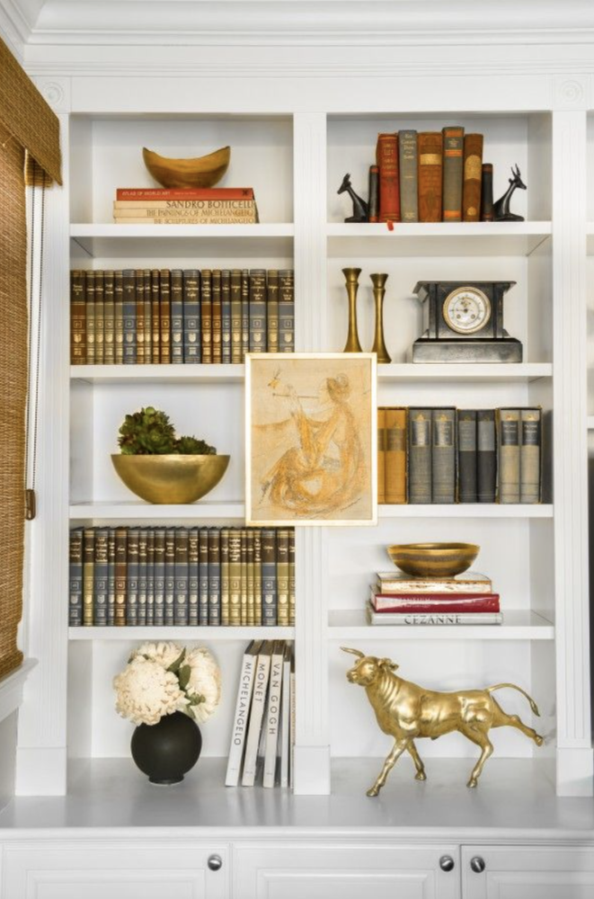 Bookcase styled with brass and gold objects