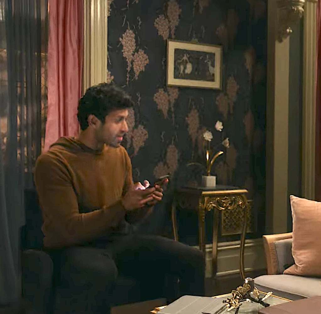 Man with cell phone in room with dark blue wallpaper