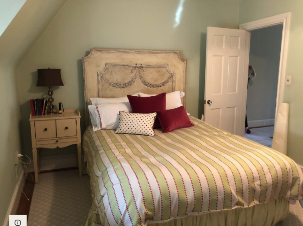 Light green bedroom with whitewashed wooden headboard
