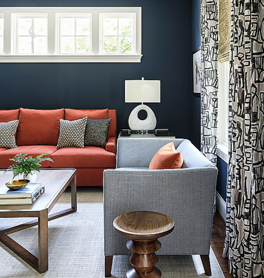 Navy blue living room with orange sofa and blue loveseat