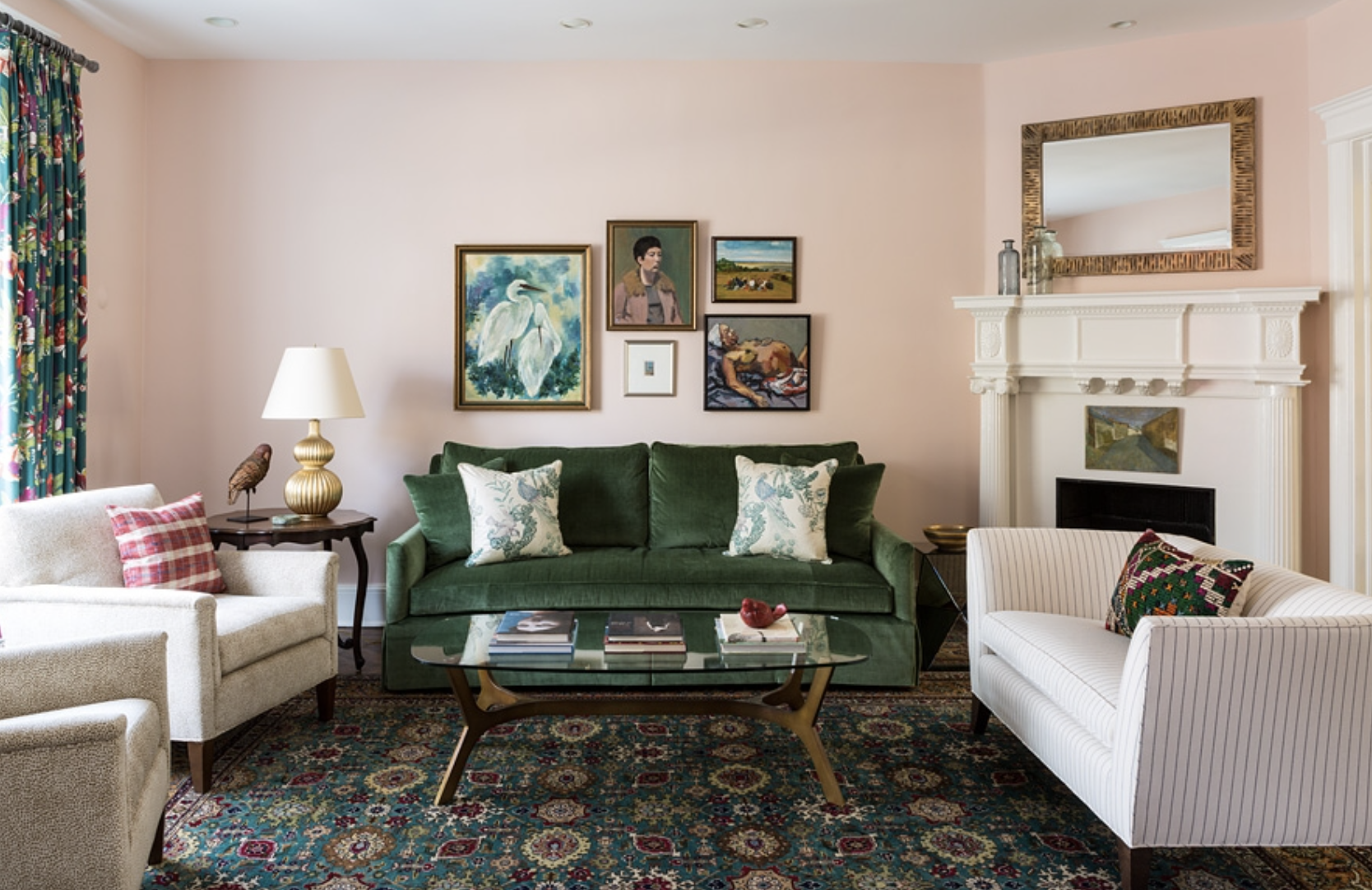 Light pink blush living room with green sofa, gallery wall, and corner fireplace