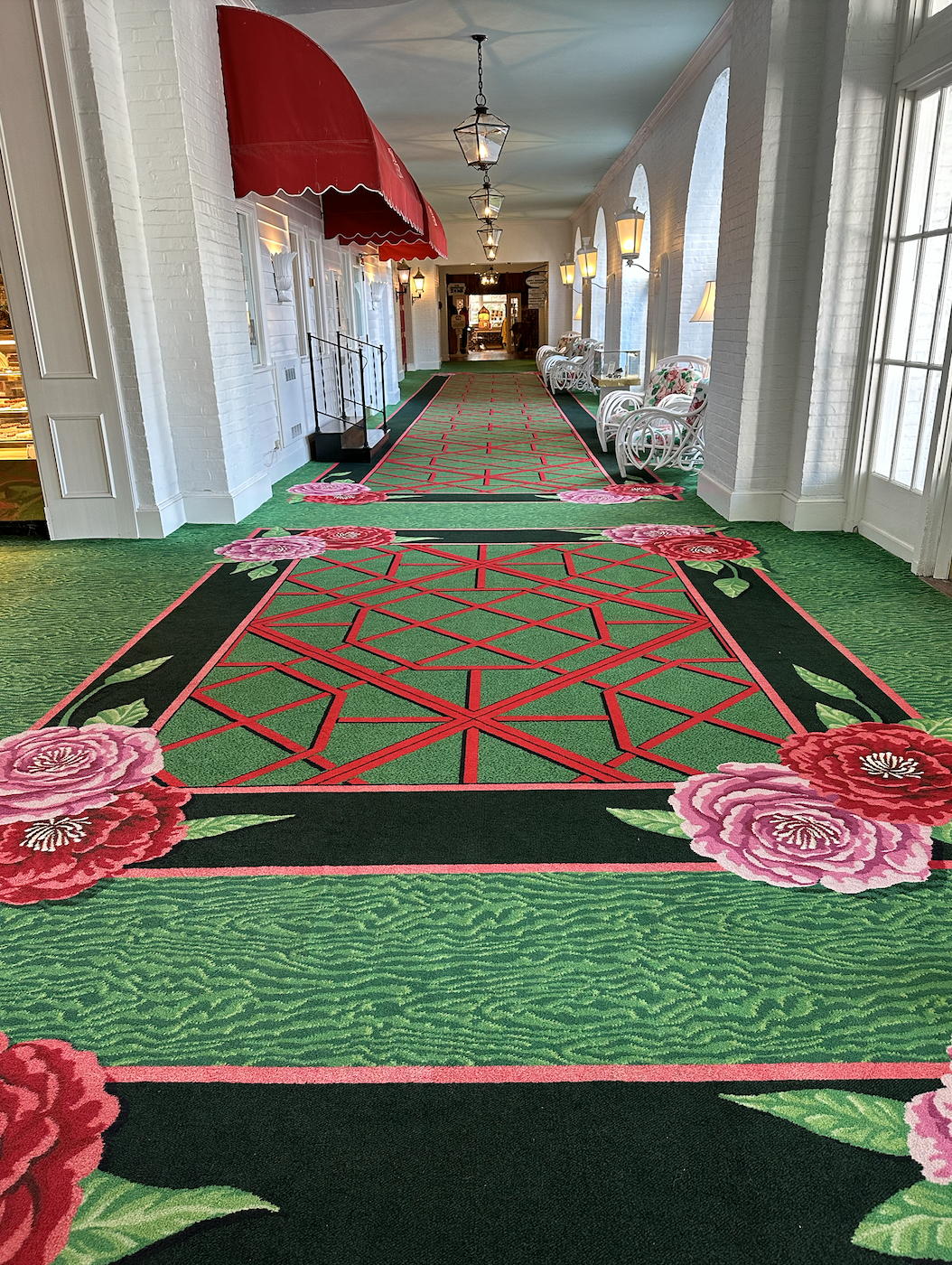 Hallway with large scale red, green, and pink carpet