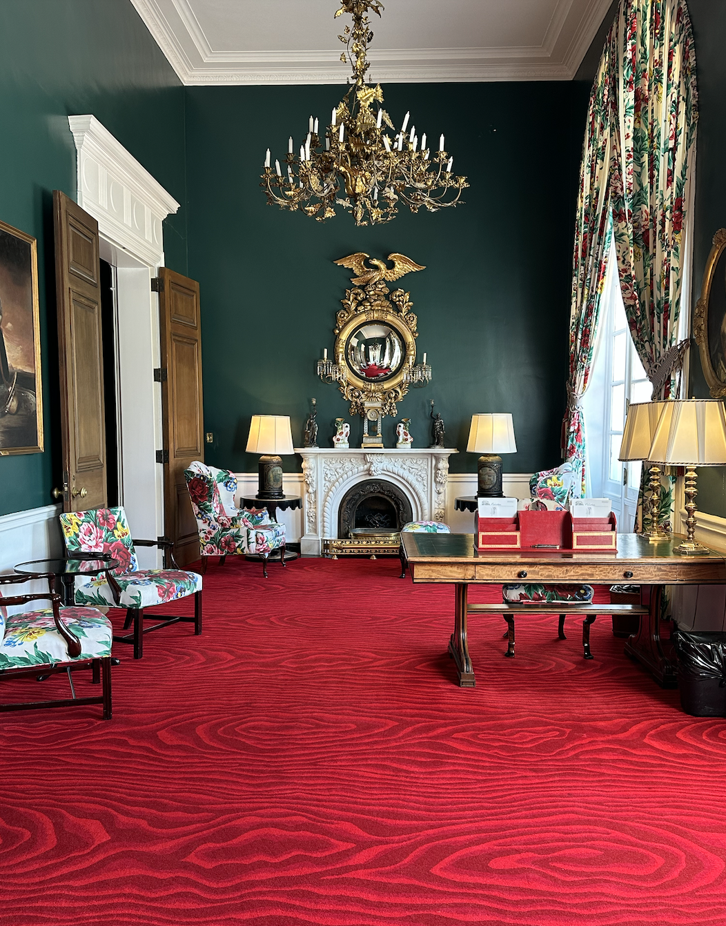 Writing room with green walls and red carpet.