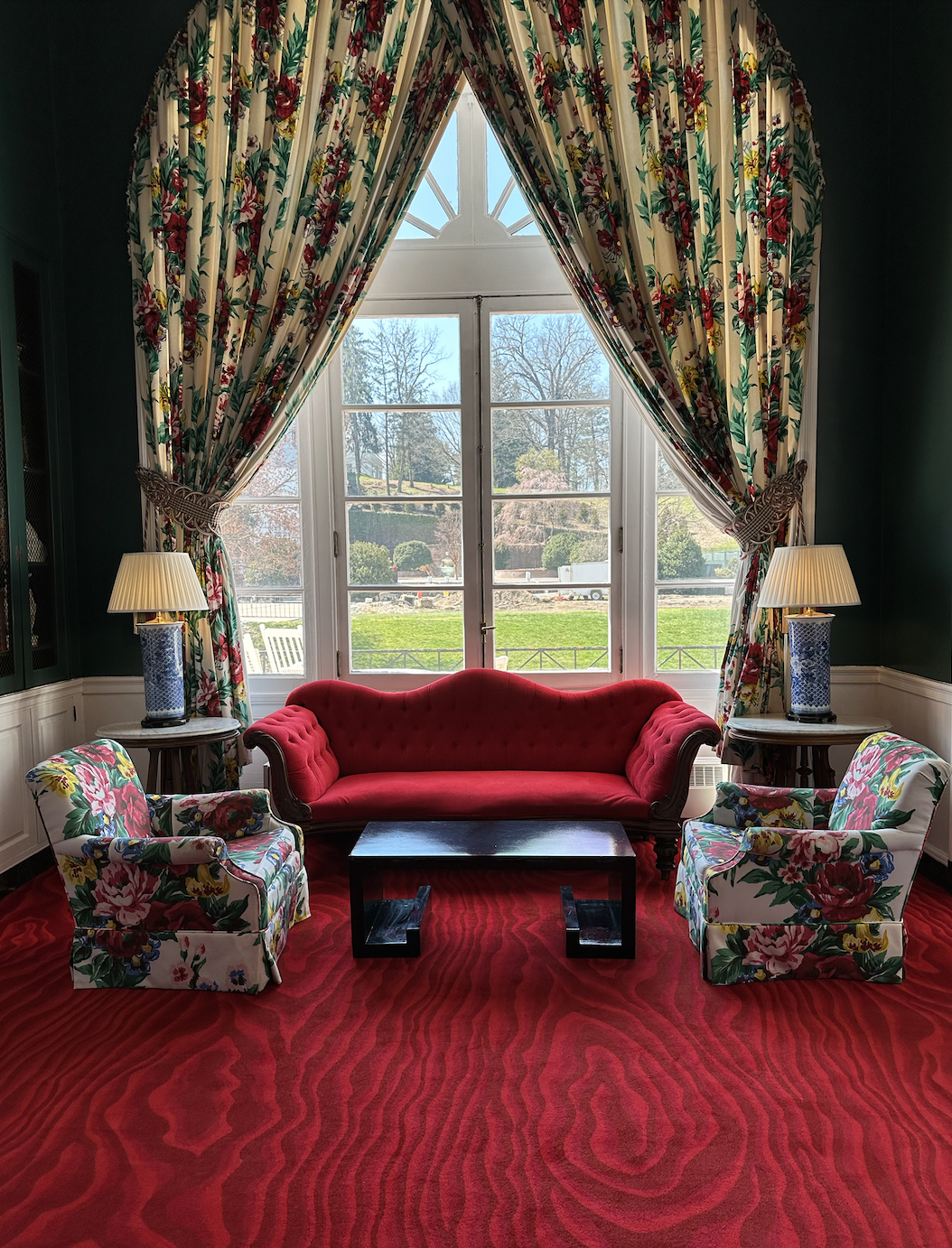 Writing room with red carpet and floral window treatments