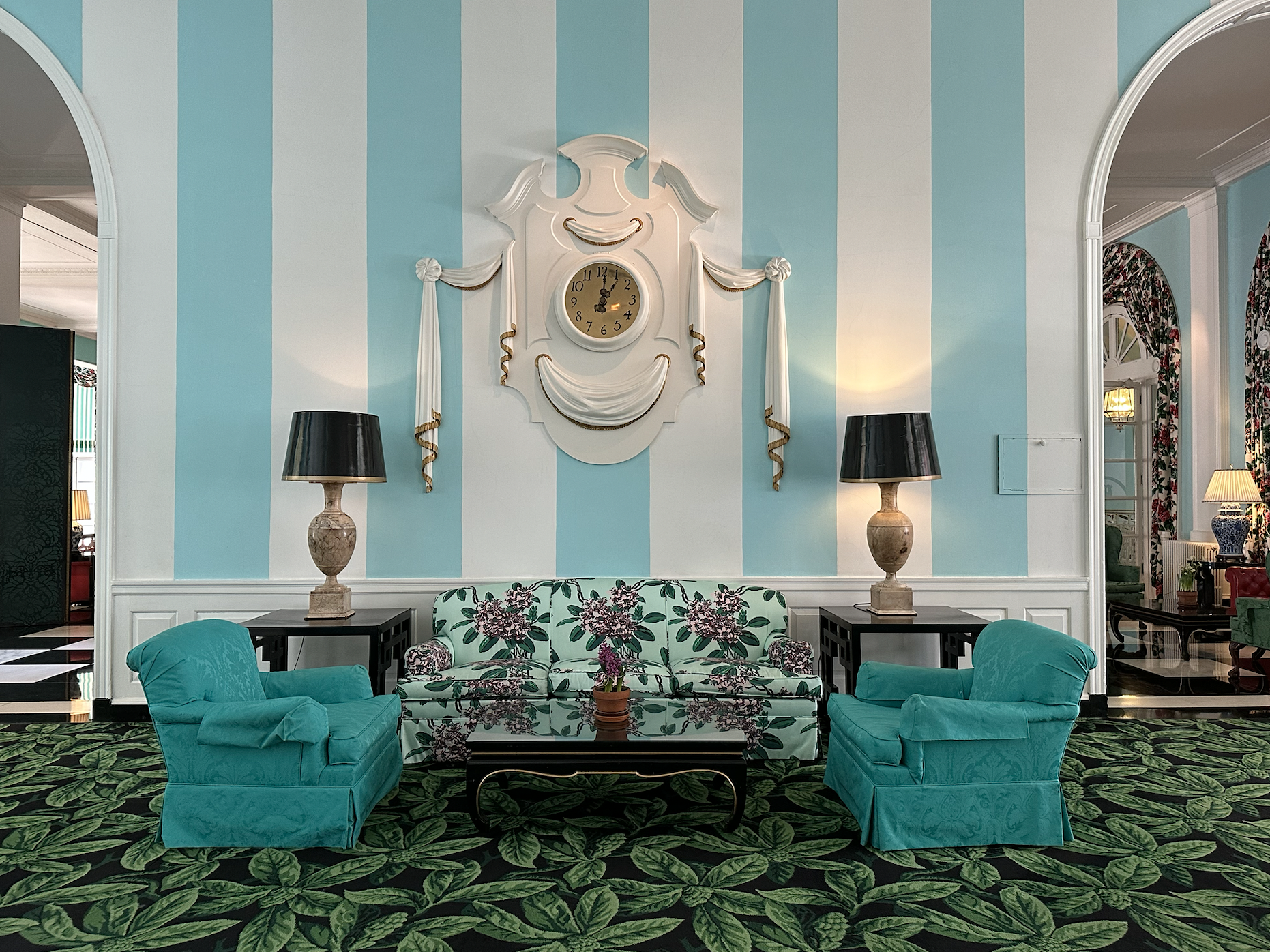 Blue and white striped wall, blue chairs, mint green sofa, dark green carpet
