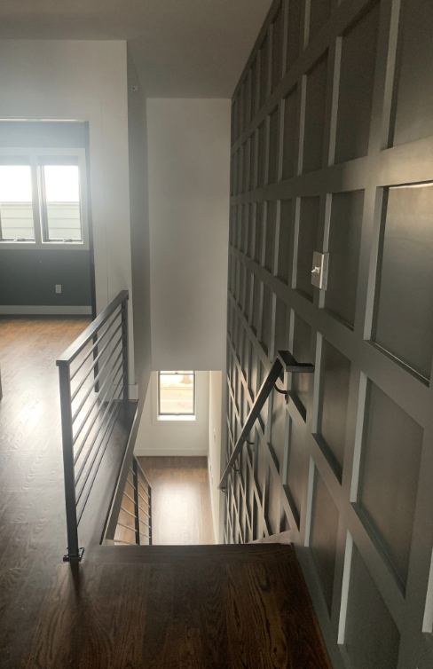 Painted gray paneled wall down staircase