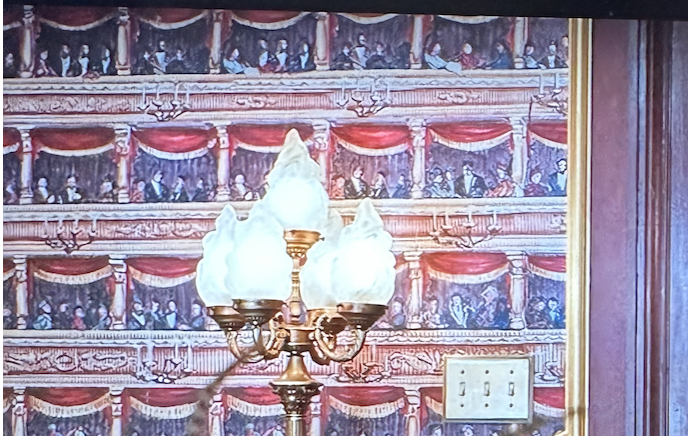 Close-up of whimsical wallpaper that looks like theater balconies 