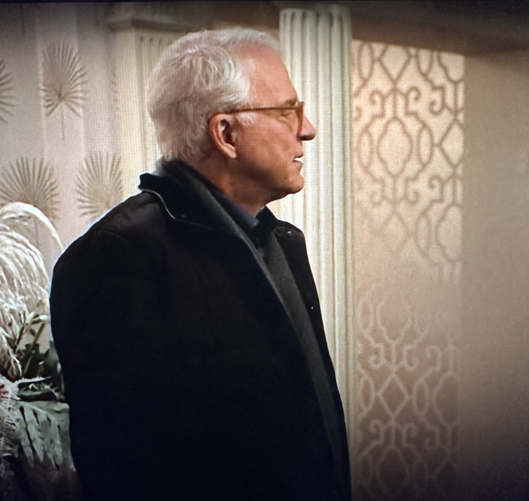 Man standing between two beige and white wallpapers