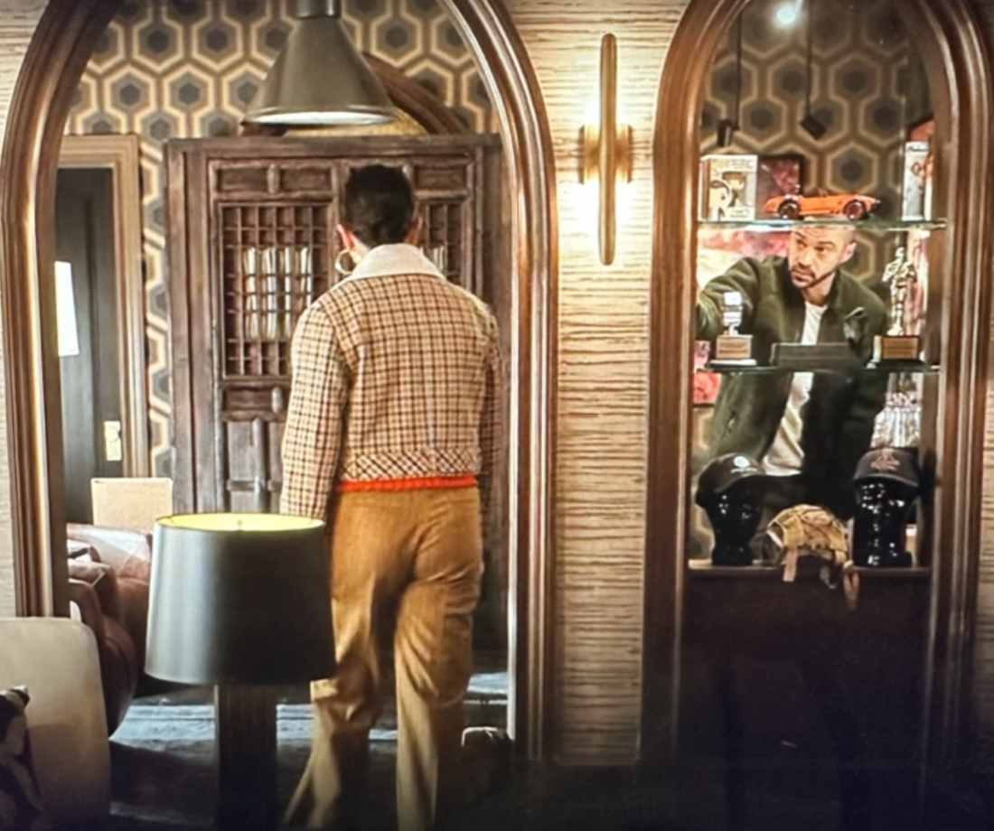 Man and woman in room with geometric wallpaper