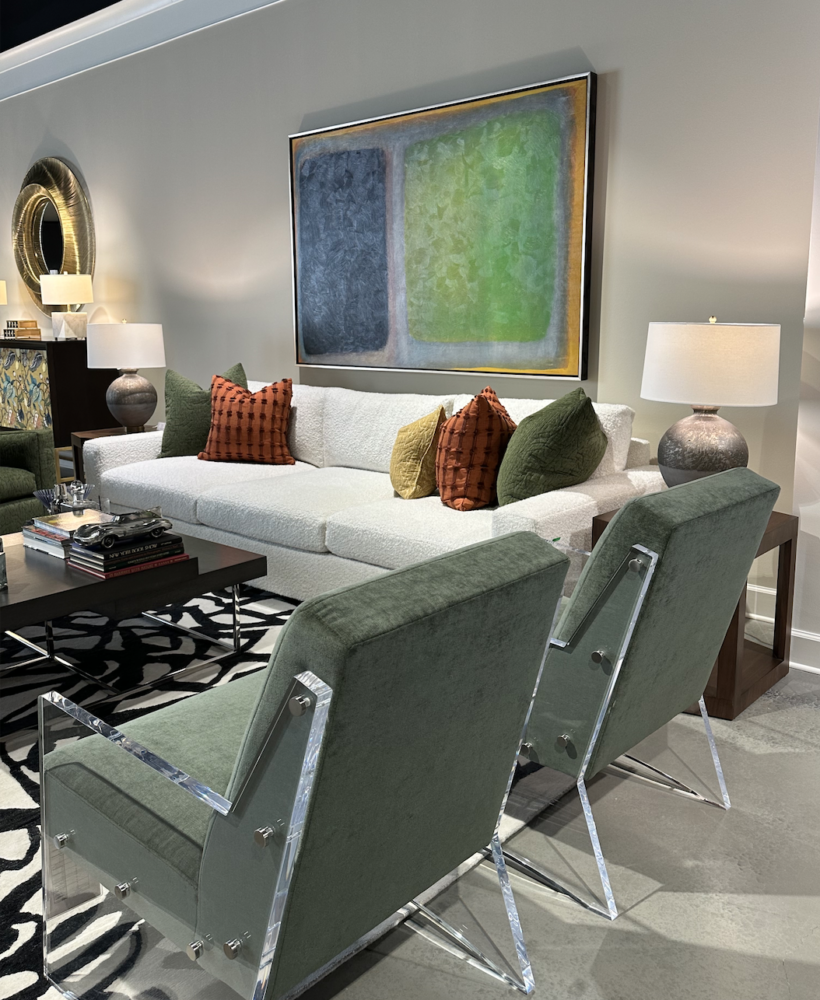 Living room with colorful painting, white sofa, and green lounge chairs