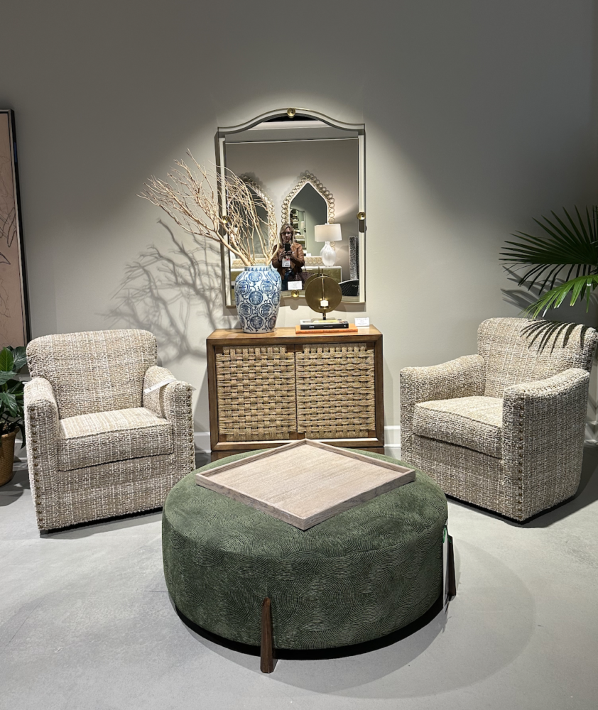 Beige living room with 2 chairs and round green ottoman