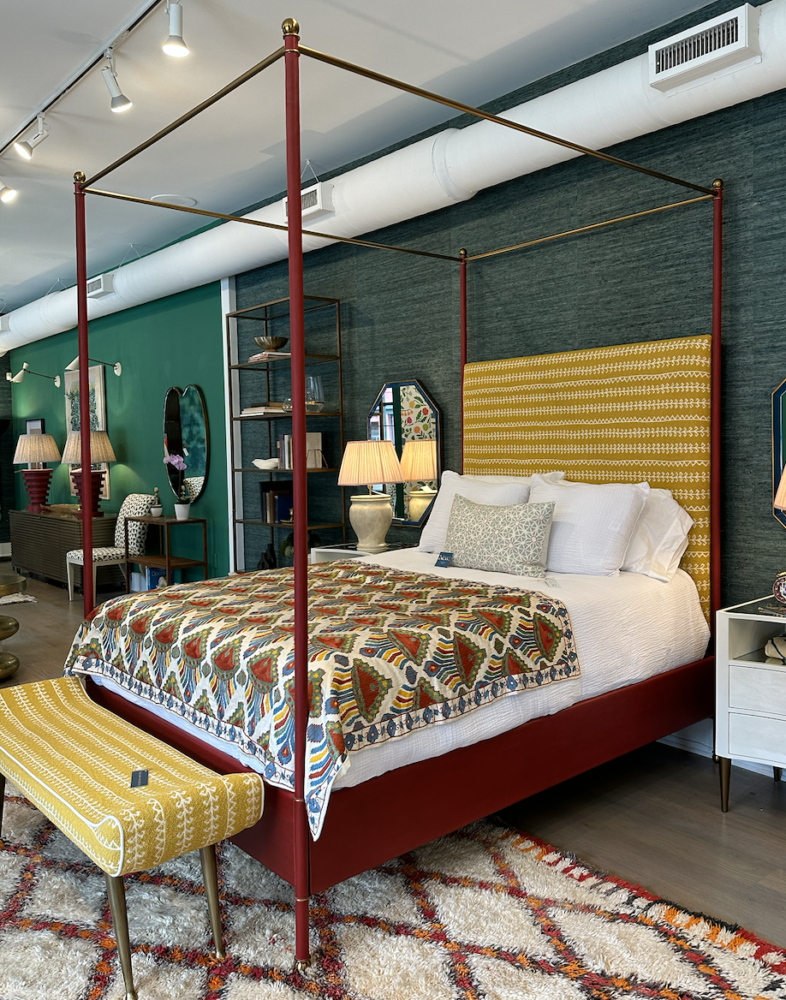 Red four-poster upholstered bed in colorful bedroom