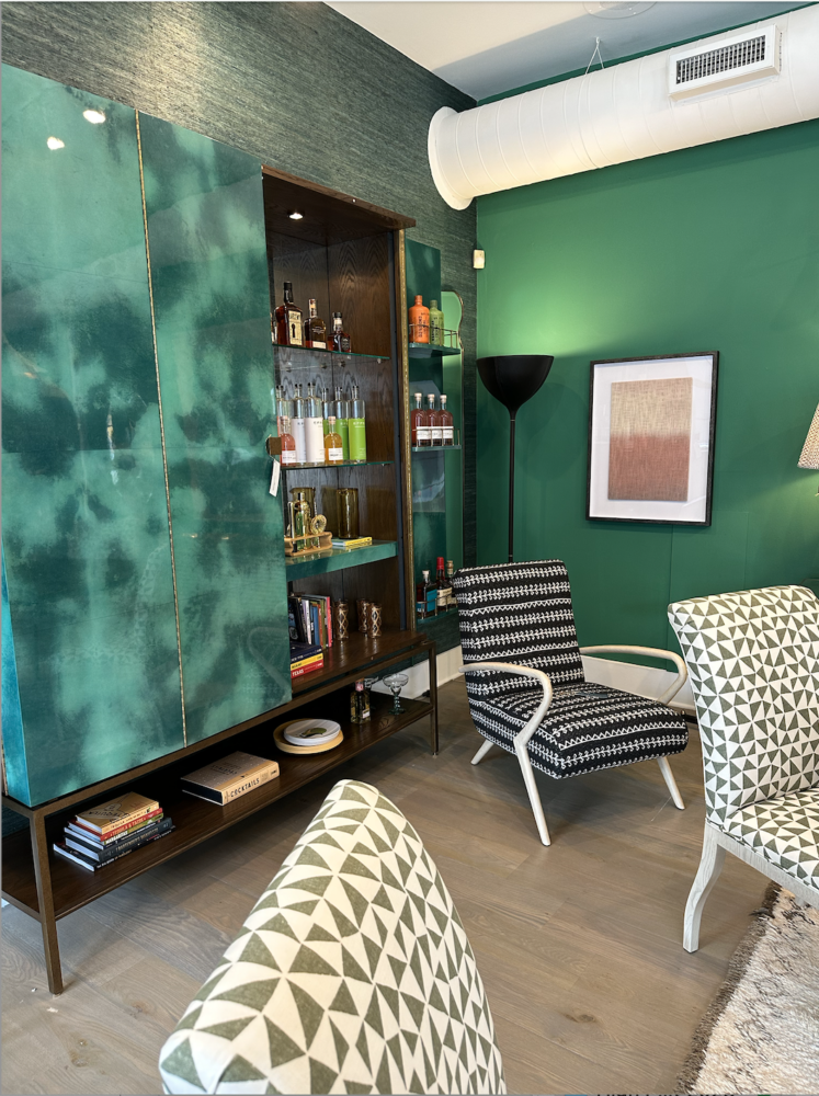 Room with green walls and large home bar cabinet
