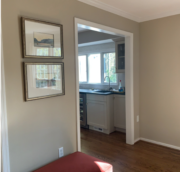 Doorway from a tan room into a kitchen