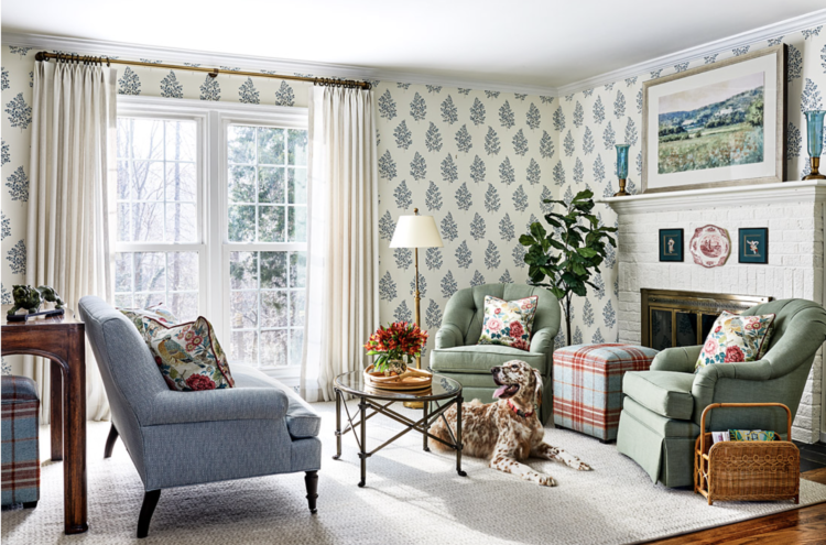 Bright, cheerful family room with blue and white wallpaper, white brick fireplace, sage green chairs, and light blue sofa