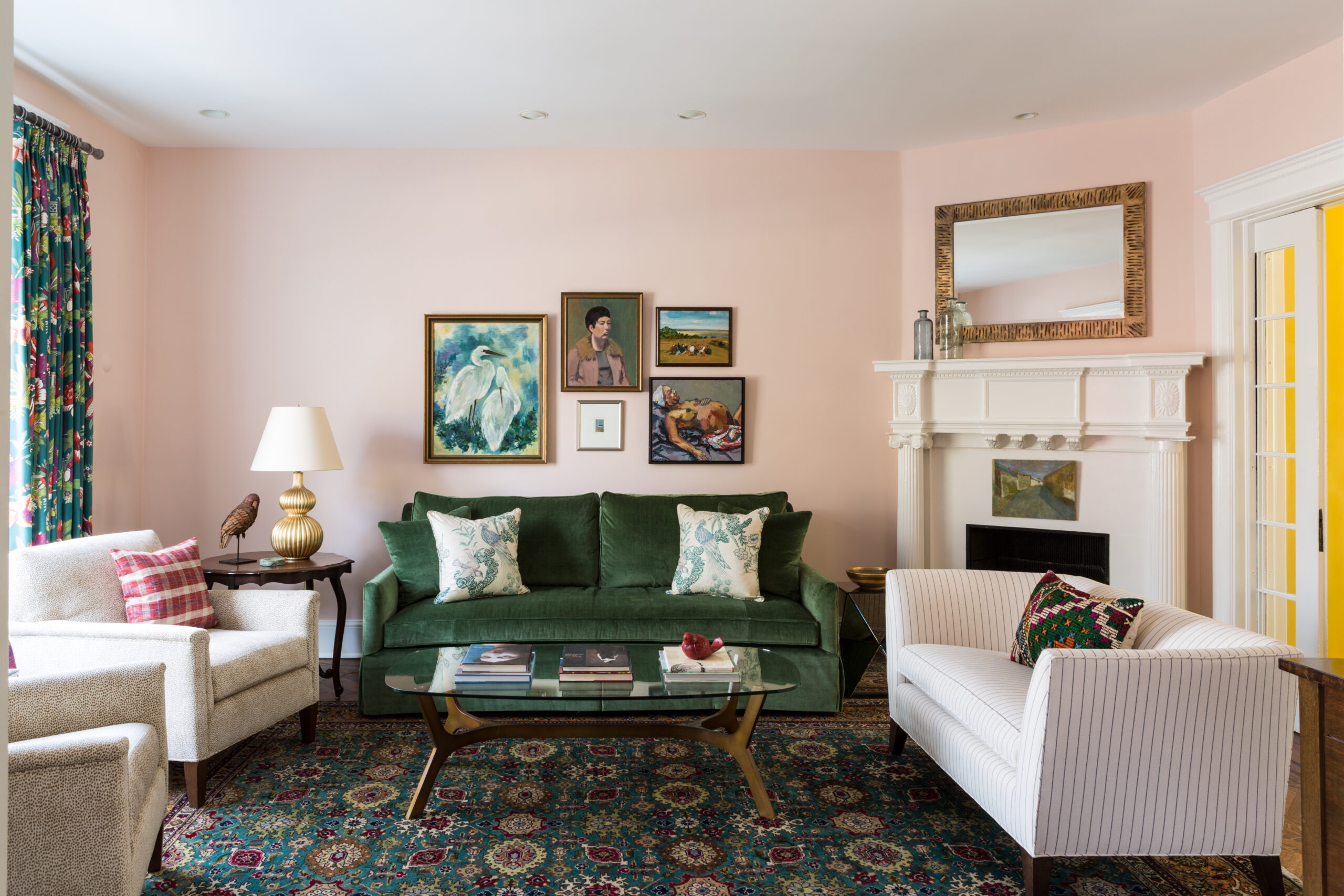 Living room in northwest Washington, DC with pink walls, a green sofa, and an antique rug