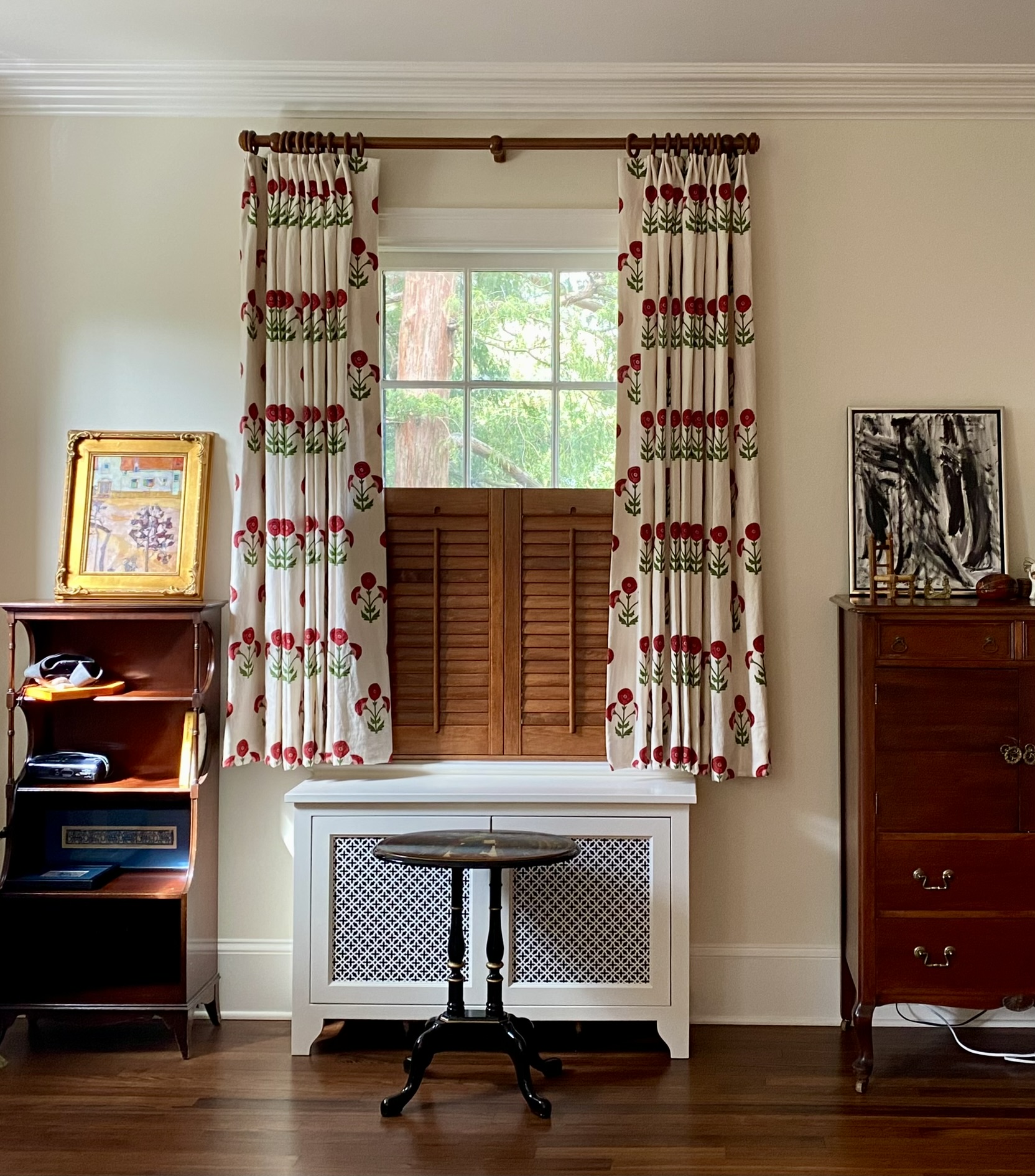 Red and green flowered curtains over a wooden shutter
