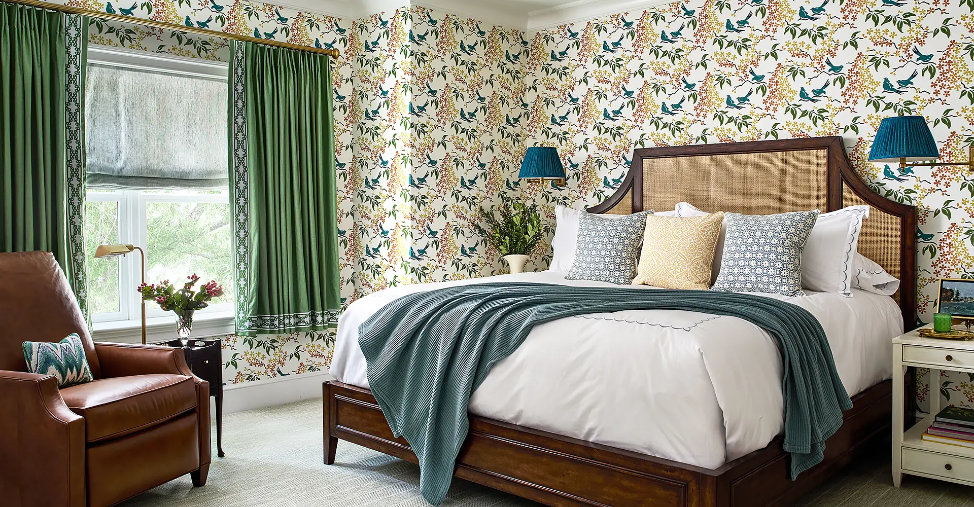Bedroom design showing bed linens, custom window treatments, wallpaper, reading sconces and wall to wall carpeting.