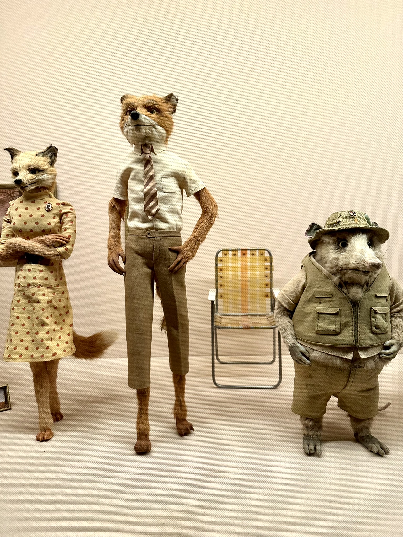 Furry models of foxes and a an opossum wearing clothes