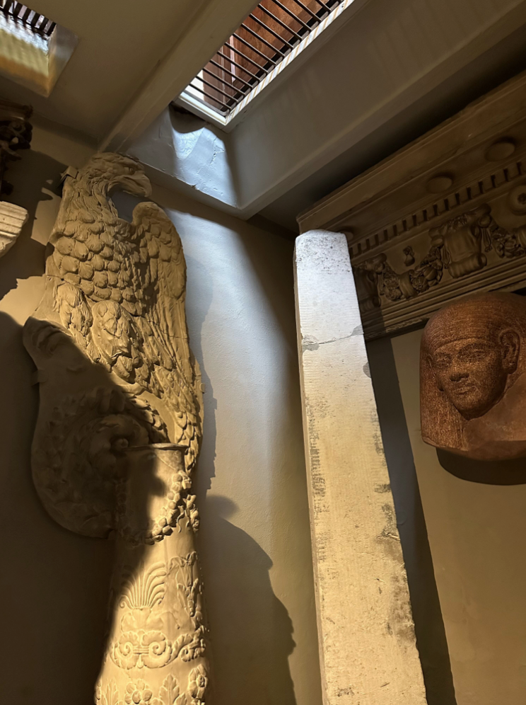 Basement-level museum room with hole in ceiling allowing light from room above.