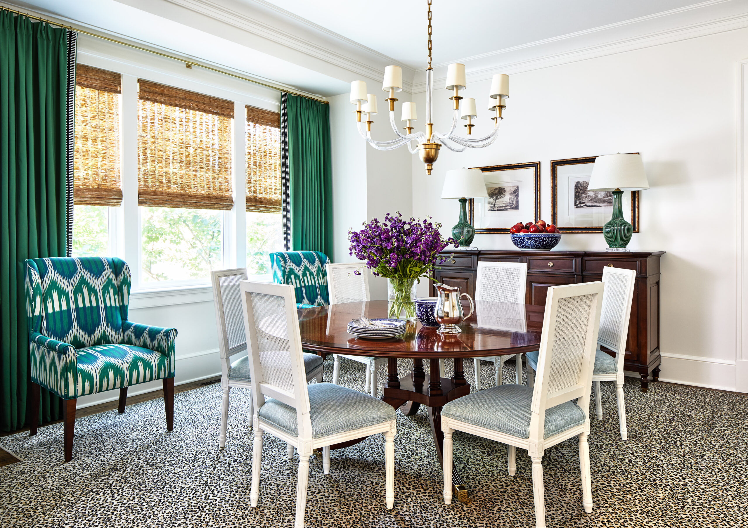 Dining room with natural woven Roman shades and green drapes