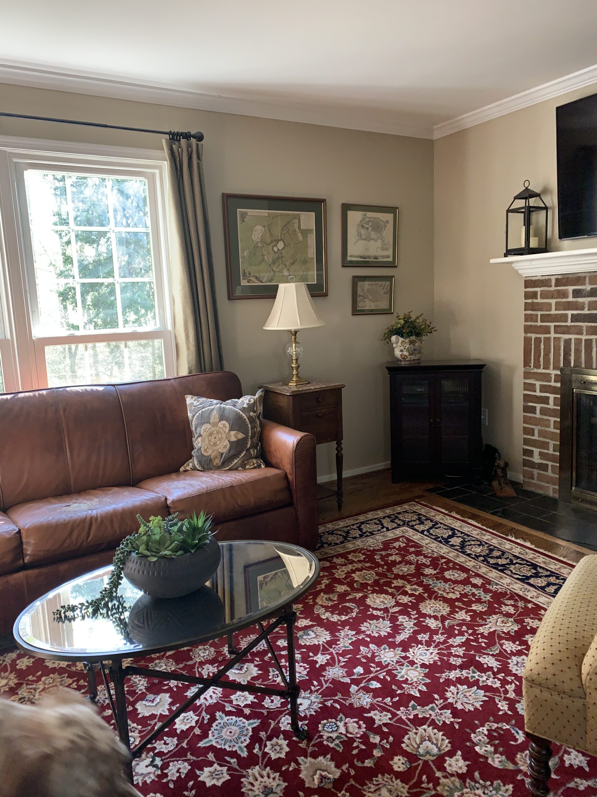 Leather couch, red and blue rug, and fireplace.