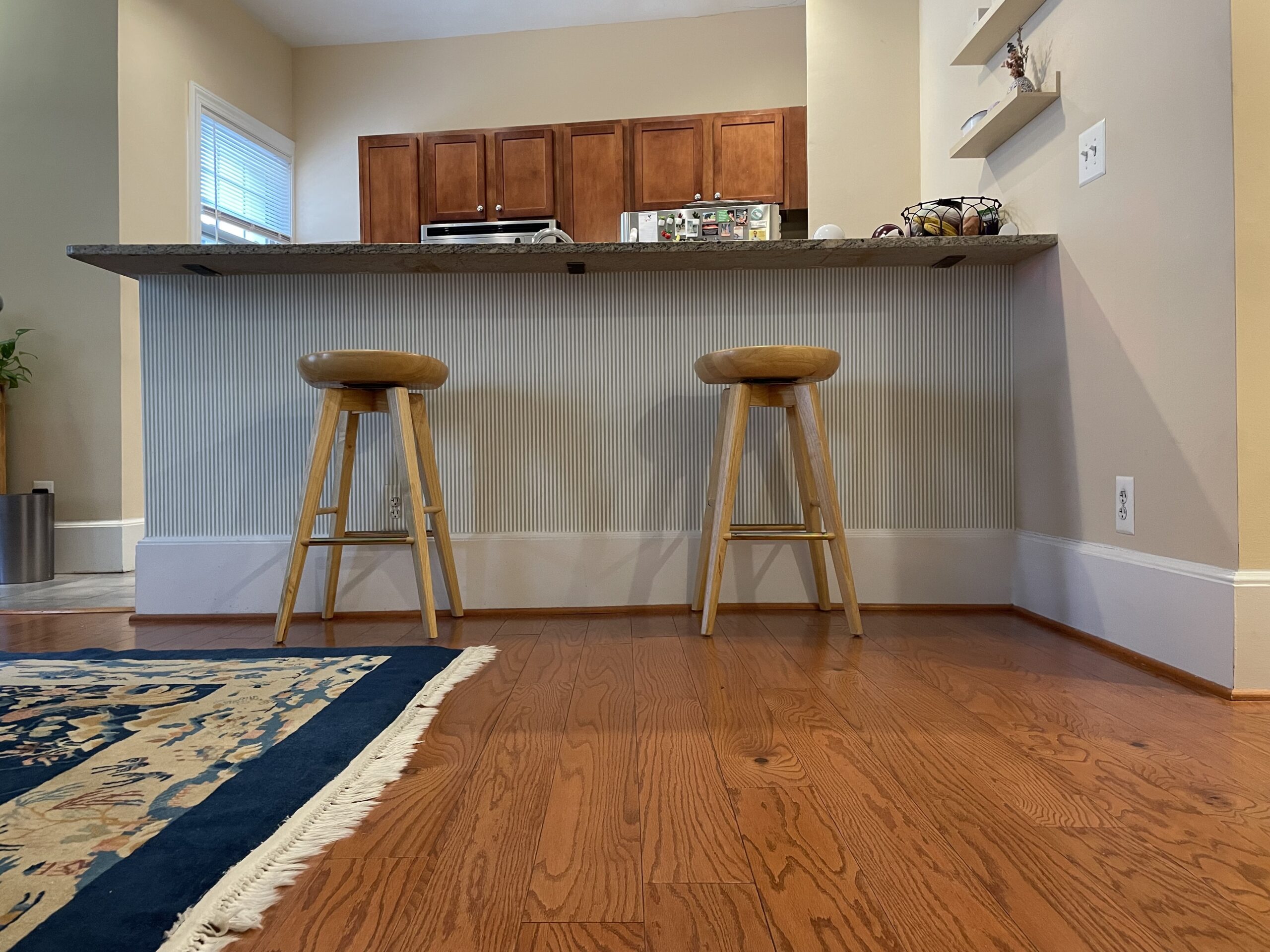 White and green striped wallpaper under a kitchen counter.