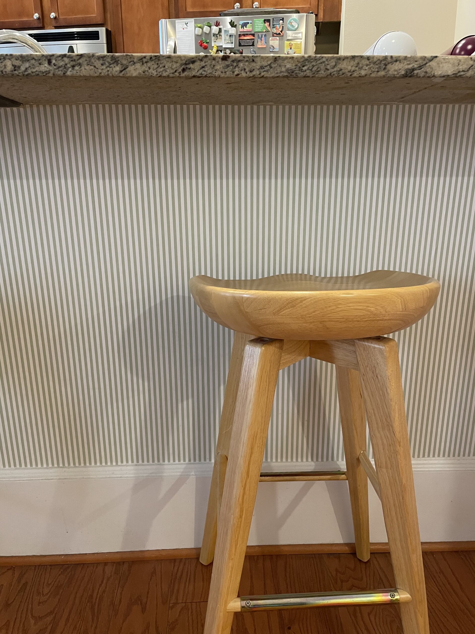 White and green striped wallpaper under a kitchen counter.