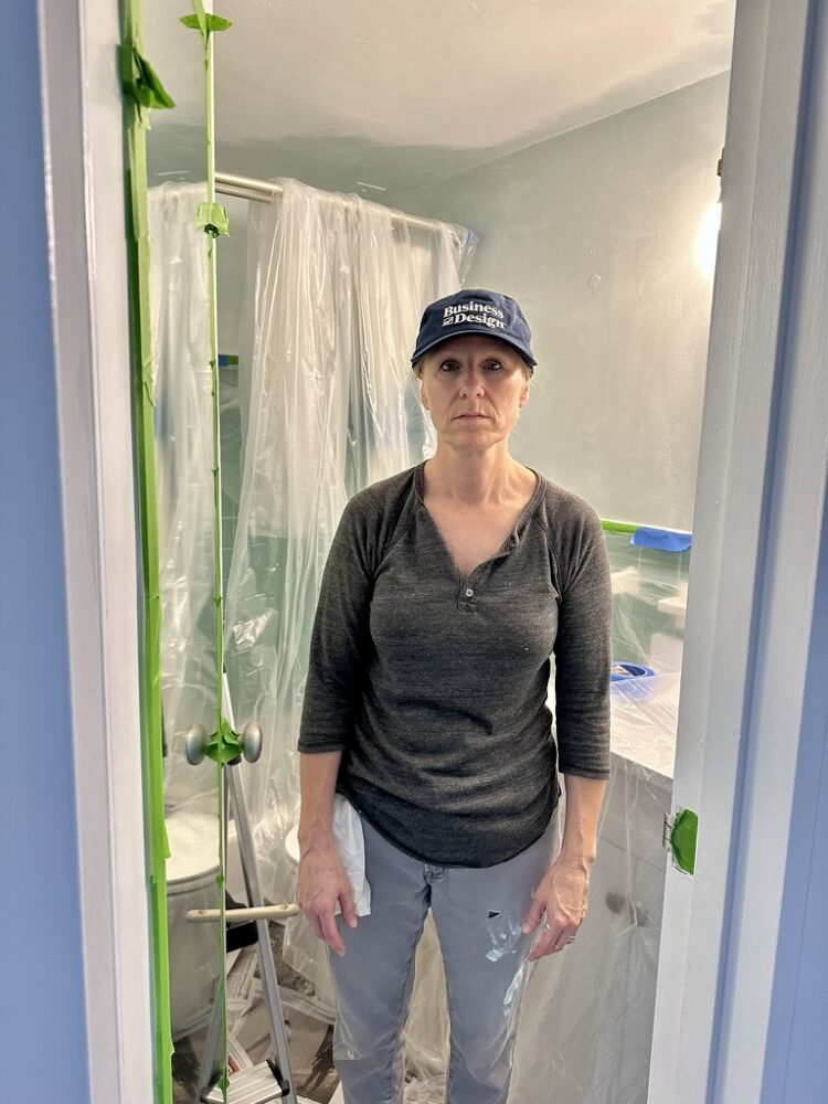 Sad woman in half-painted bathroom