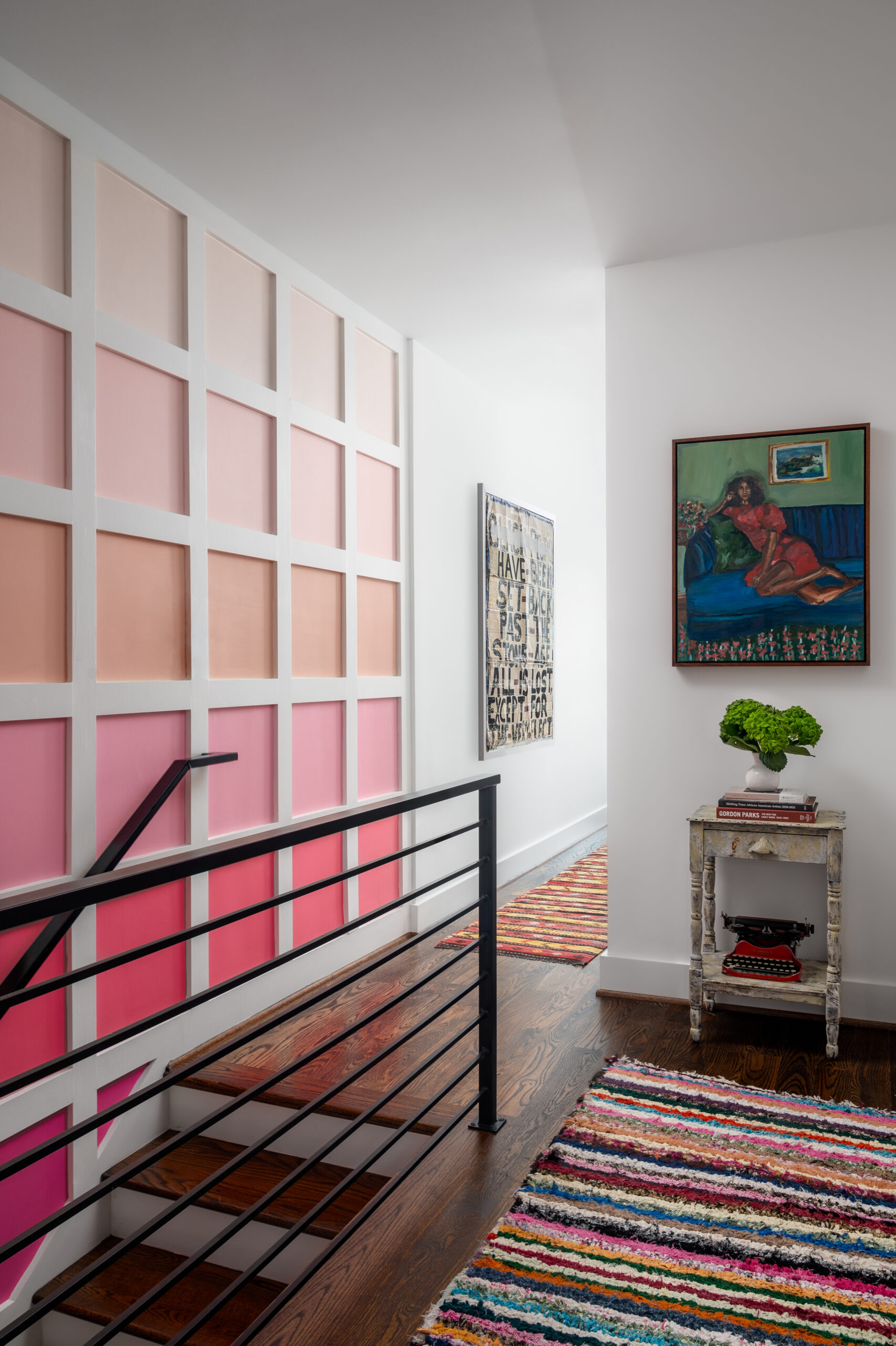 Stair hallway with grid of varying pink squares with white trim.