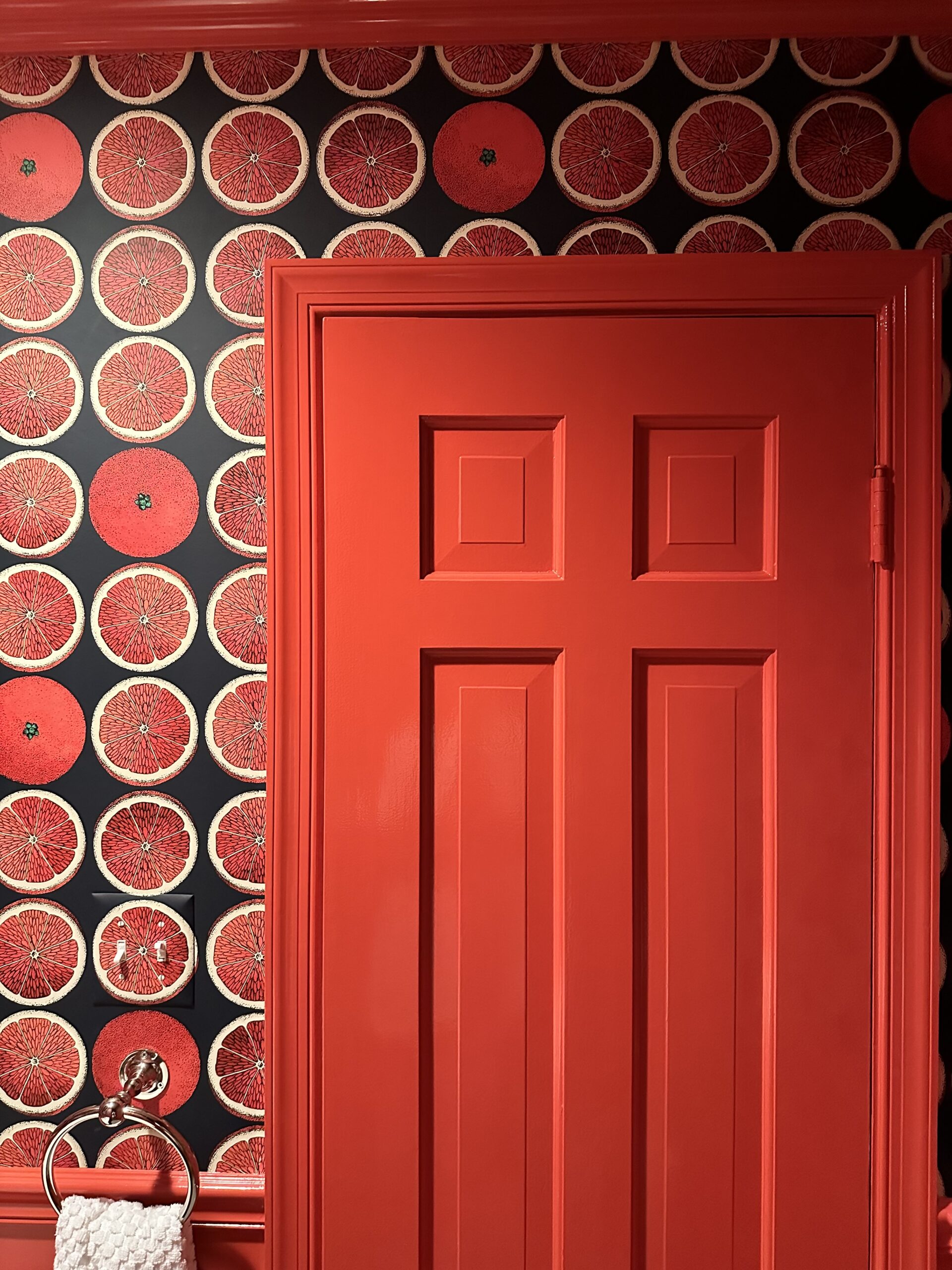 Room with red door, red trim, and black and red wallpaper.