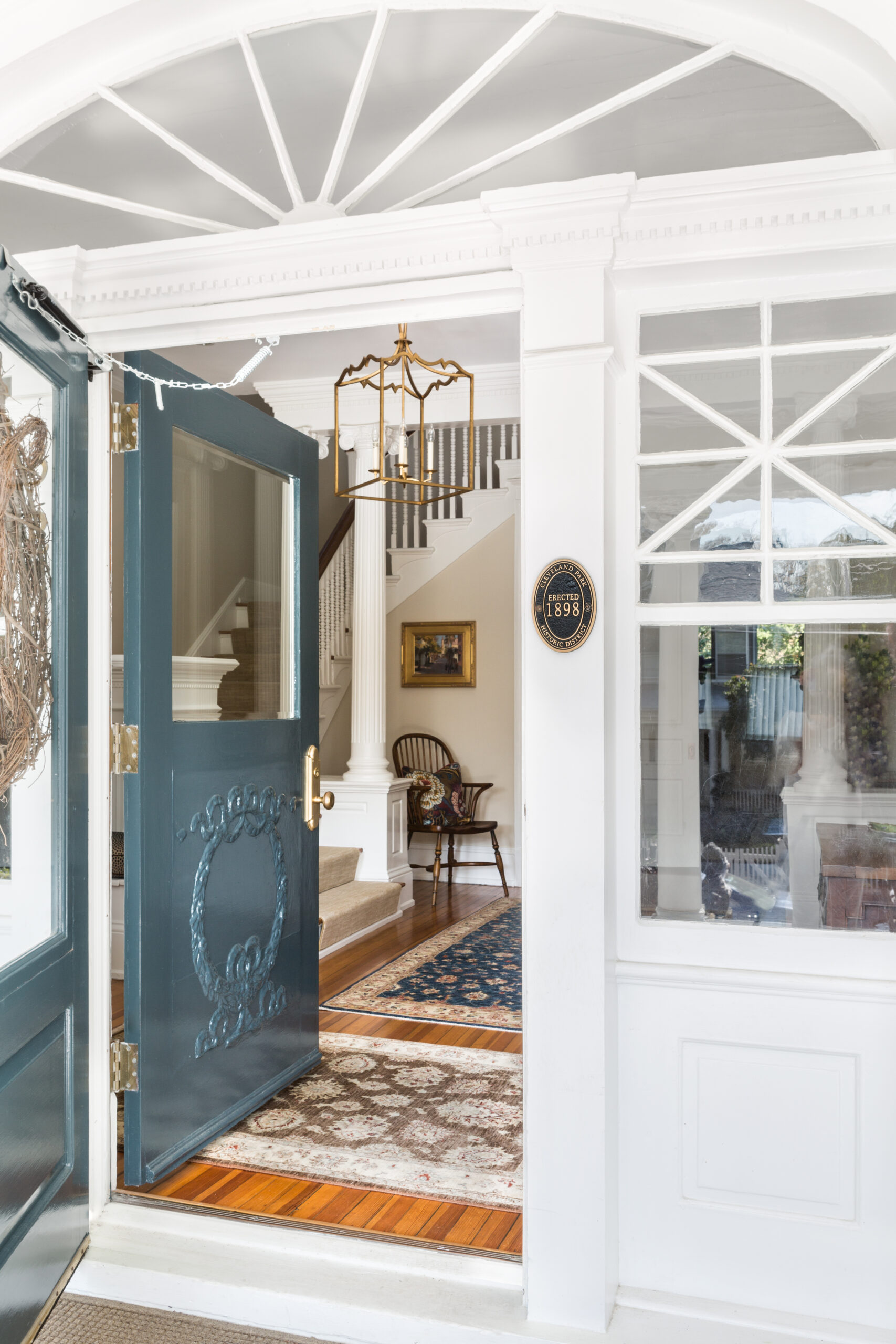 Entrance to house with blue door and white trim and woodwork.
