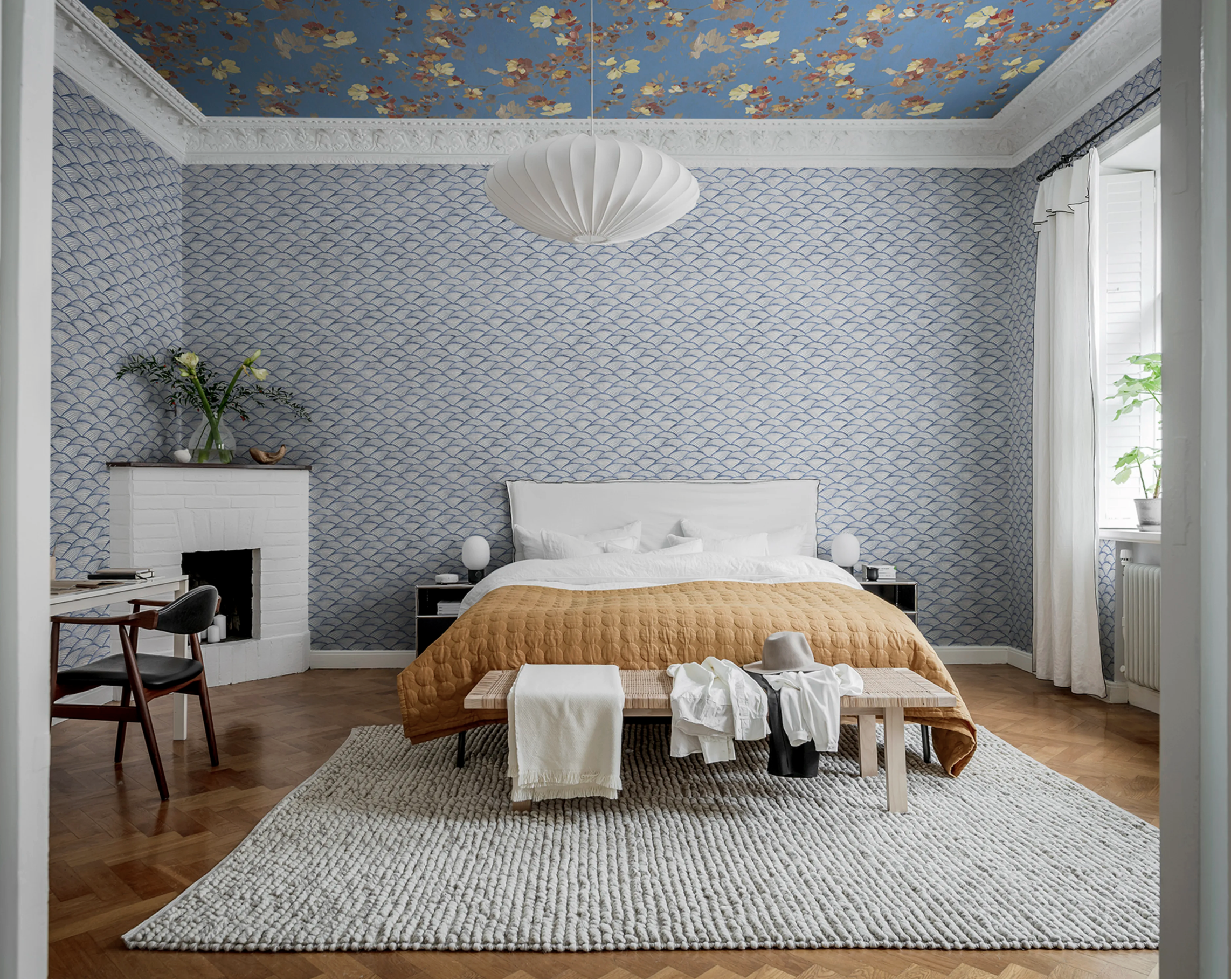Room with different blue wallpapers on walls and ceiling.