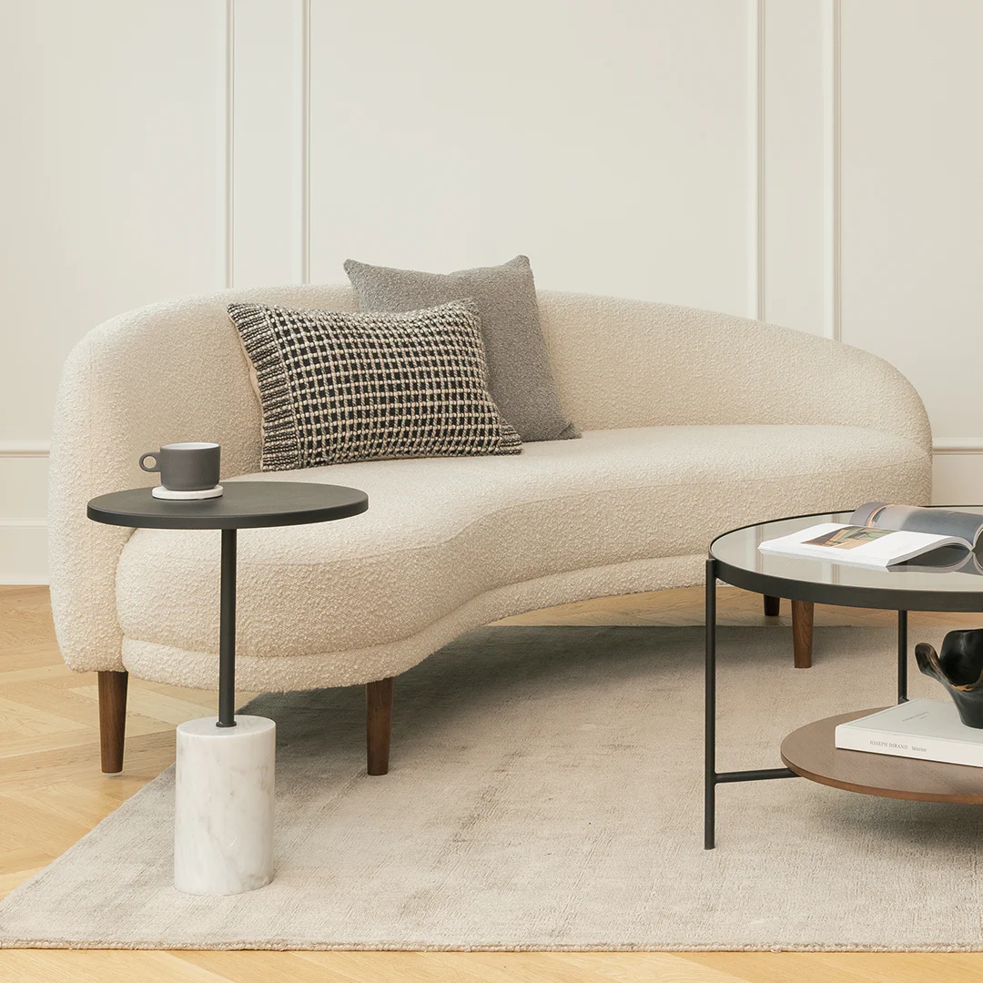 Curved ivory sofa with side table.