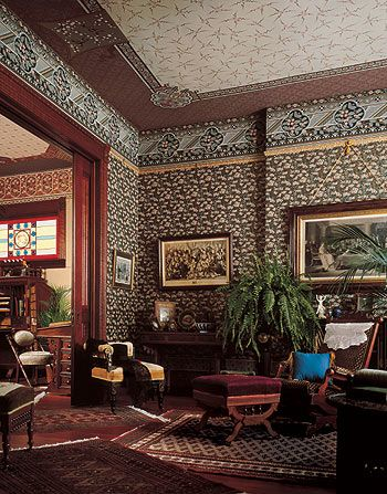 Crowded living room with wallpaper on walls and ceiling