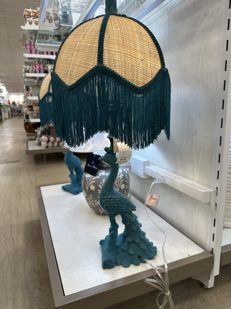 Teal peacock lamp with a fringed shade.