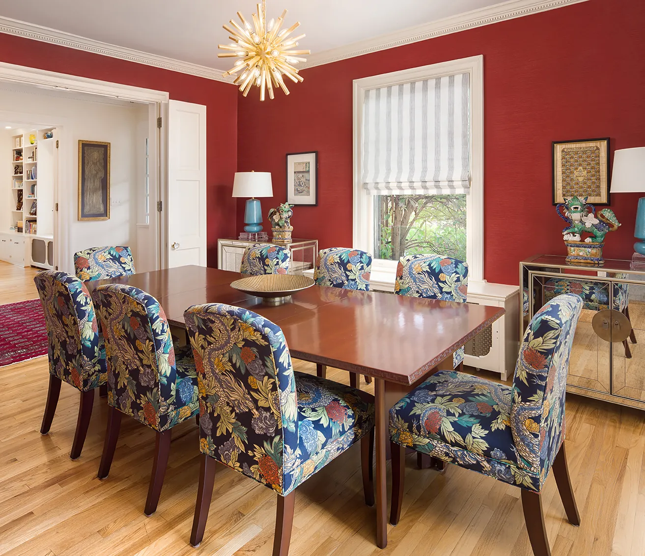 Woodley Park dining room design with richly colored wallpaper, upholstered chairs and mirror consoles in Asian design