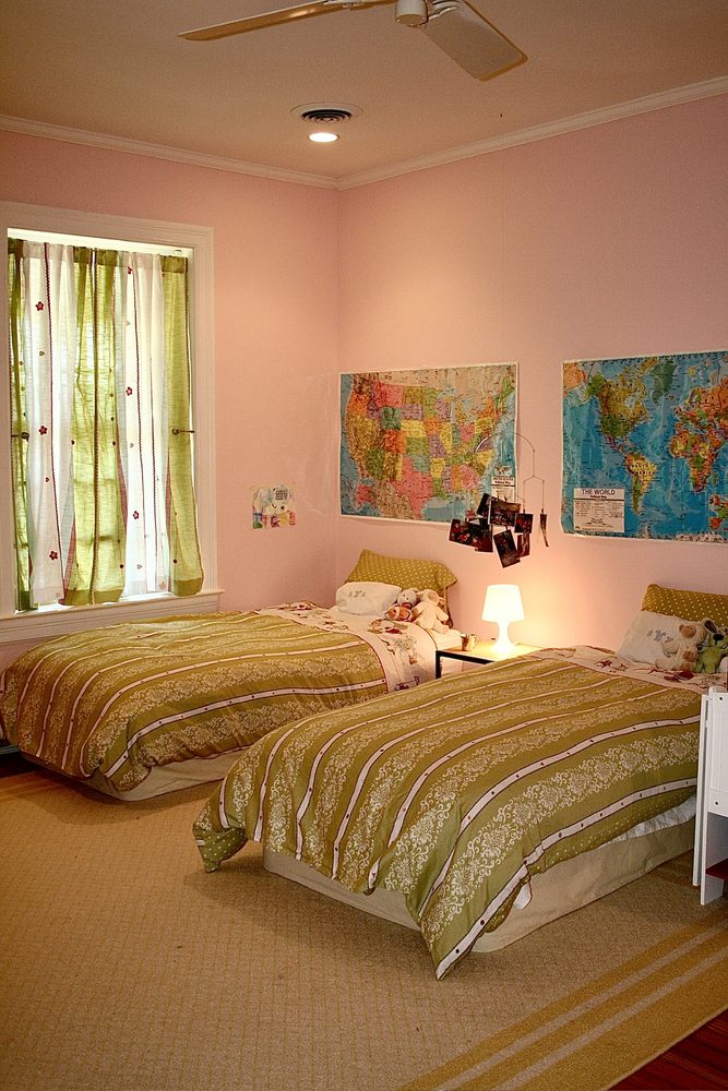 Pink girls' bedroom with matching twin beds and green bedding