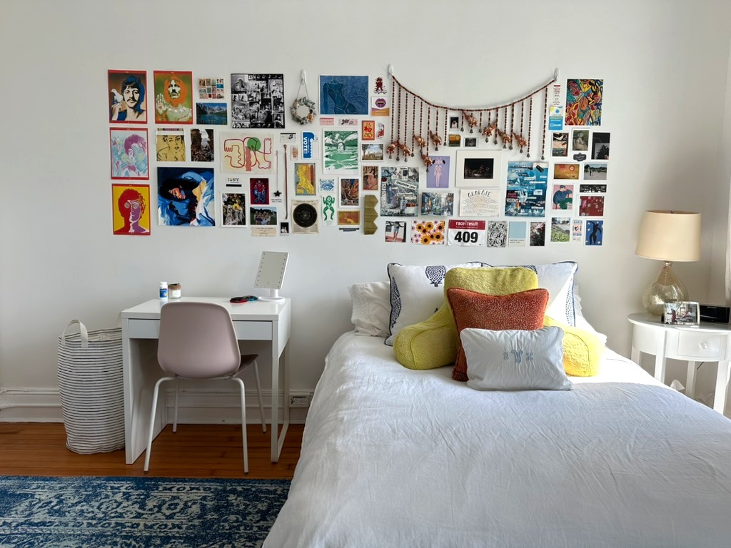 Bedroom with mementos on a white gallery wall